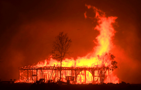 The Historic Round Barn burns, Monday Oct. 9, 2017, in Santa Rosa, Calif. More than a dozen wildfires whipped by powerful winds been burning though California wine country. The flames have destroyed at least 1,500 homes and businesses and sent thousands of people fleeing. (Kent Porter/The Press Democrat via AP)