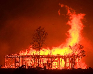 The Historic Round Barn burns, Monday Oct. 9, 2017, in Santa Rosa, Calif. More than a dozen wildfires whipped by powerful winds been burning though California wine country. The flames have destroyed at least 1,500 homes and businesses and sent thousands of people fleeing. (Kent Porter/The Press Democrat via AP)