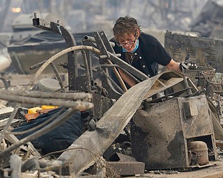Kristine Pond reacts as she searches the remains of her family's home destroyed by fires in Santa Rosa, Calif., Monday, Oct. 9, 2017. (AP Photo/Jeff Chiu)