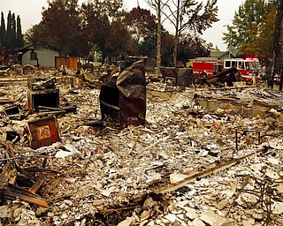 Firefighters drive through the Coffey Park area of Santa Rosa, Calif., looking for hotspots on Tuesday, Oct. 10, 2017. An onslaught of wildfires across a wide swath of Northern California broke out almost simultaneously then grew exponentially, swallowing up properties from wineries to trailer parks and tearing through both tiny rural towns and urban subdivisions. (AP Photo/Ben Margot)
