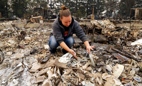 Gina Baier looks for family heirloom china that may have survived in the remains of her home in the Coffey Park area of Santa Rosa, Calif., on Tuesday, Oct. 10, 2017. An onslaught of wildfires across a wide swath of Northern California broke out almost simultaneously then grew exponentially, swallowing up properties from wineries to trailer parks and tearing through both tiny rural towns and urban subdivisions. (AP Photo/Ben Margot)