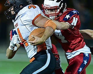 NILES, OHIO - OCTOBER 12, 2017: Howland's Jackson Deemer, left, runs the ball while being tackled by Niles' Trent Johnson during the first half of their game Thursday night at Niles McKinley High School. DAVID DERMER | THE VINDICATOR
