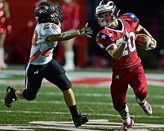 NILES, OHIO - OCTOBER 12, 2017: Niles' kick returner Brandon Golias, right, runs away from the hand of Howland's Eric Babinchak during the first half of their game Thursday night at Niles McKinley High School. DAVID DERMER | THE VINDICATOR