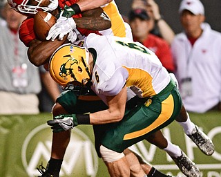 YOUNGSTOWN, OHIO - OCTOBER 14, 2017: Youngstown State's Damoun Patterson hangs on to a touchdown pass while being hit by North Dakota State's Levi Jordheim and James Hendricks during the first half of their game Saturday night at Stambaugh Stadium. DAVID DERMER | THE VINDICATOR