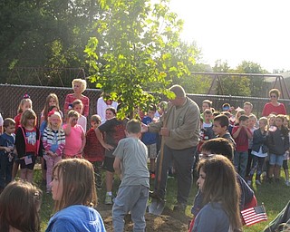 Neighbors | Zack Shively  .Jerry Blasco helped students turn over soil on a tree that Blasco had donated for the Patriot Day event. The tradition of turning over soil on a donated tree has been going on since the first Patriot Day.