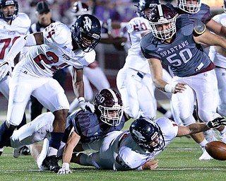 BOARDMAN, OHIO - OCTOBER 20, 2017:   Austintown's Joseph Zielinski (12) reaches for his fumble as Boardman's Connor Miller (33) makes the tackle and Boardman's Steven Amstutz (50) and Austintown's Jakari Lumsden eye the fumble (24) during the 2nd qtr. at Spartan Stadium. MICHAEL G TAYLOR | THE VINDICATOR