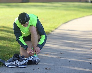 Sam Lander of Oil City, Pa. ties his shoe laces before the 42nd annual Youngstown Peace Race, Sunday, Oct. 22, 2017, in Youngstown...(Nikos Frazier | The Vindicator)