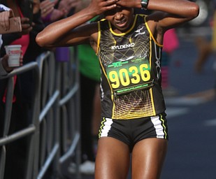 Margaret Wanjiru(9036) holds her head as she approaches the finish line while the crowd cheers her on during the 42nd annual Youngstown Peace Race, Sunday, Oct. 22, 2017, in Youngstown. Wanjiru placed second among women with a time of 33:49...(Nikos Frazier | The Vindicator)