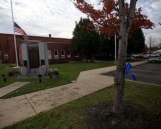 The flag outside of the City of Girard government building stands at half staff, with tries lining the property tied with blue ribbons for the late Girard Police Officer Justin Leo, Sunday, Oct. 22, 2017, at outside the City Justice Center in Girard. Officer Leo was killed while responding to a potential suicide around 10:00 p.m., Saturday, Oct. 21, 2017, on the 400 block of Indiana Ave in Girard. Officer Leo was transported to St. ElizabethÕs Youngstown for surgery where he later died. ..(Nikos Frazier | The Vindicator)