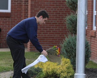 Jeff Vrabel of Poland plays flowers at the foot of the flag pole for the late Girard Police Officer Justin Leo, Sunday, Oct. 22, 2017, at outside the City Justice Center in Girard. Officer Leo was killed while responding to a potential suicide around 10:00 p.m., Saturday, Oct. 21, 2017, on the 400 block of Indiana Ave in Girard. Officer Leo was transported to St. ElizabethÕs Youngstown for surgery where he later died. ..(Nikos Frazier | The Vindicator)