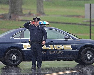 GIRARD, OHIO - OCTOBER 23, 2017: A Girard Police Officer salutes, while blocking traffic, as the motorcade for Officer Justin Leo as it drives to Blackstone Funeral Home on Churchhill Road, Monday afternoon. DAVID DERMER | THE VINDICATOR