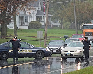 GIRARD, OHIO - OCTOBER 23, 2017: Girard Police Officer ssalutes, while blocking traffic, as the motorcade for Officer Justin Leo as it drives to Blackstone Funeral Home on Churchhill Road, Monday afternoon. DAVID DERMER | THE VINDICATOR