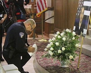 William D Lewis The Vindicator Niles PD officer Chris Manella pauses in front of a photo of slain Girard PD officer Justin Leo during a prayer vigil at St. rose Church in Girard 10-24-17.