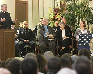 William D. Lewis The Vindicator Msgr John Zurraw, pastor of St Rose Church speaks during a prayer vigil for slain GPD officer Justin Leo 10-24-17. Leo's photo is at right.