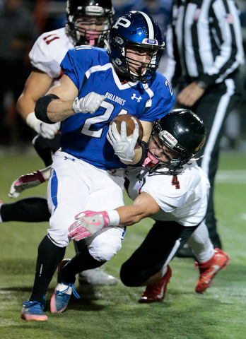 POLAND, OHIO - OCTOBER 27, 2017:   Poland's Dante Romano (21) is stopped for a short gain by Canfield's Paul Brienz (4) during the 1st qtr. at Poland Stadium. MICHAEL G TAYLOR | THE VINDICATOR