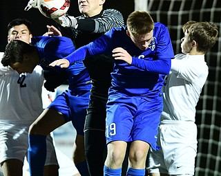 Howland goalie Michael Schwartz tips the ball away preventing Lakeview's Logan Olszewski from heading the ball during the second half of their game Saturday night. DAVID DERMER | THE VINDICATOR