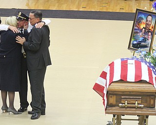 William D Lewis The vindicator Girard PD chief John Norman embraces slain officer Justin Leo's parent's Dave and Pat Leo during funeral services at YSU Beegley Center 10292017.