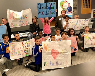 Above, Boardman Center students hold signs thanking Moore for his visit. Standing in back row, from left, are Jayden Doerr, Isabel Klisiewicz, Laci Jurus, Moore, Thomas Amon and Eric Konik. Middle row, kneeling, from left, are Alec Dabney, Manny Munoz, Kennedy Smith, David D’Altorio, Mya Guesman, Lainey Beadle and Alexis Davis. First row, kneeling in front, from left, are Austin Gardner, Shahniwaz Ali and William Smith.