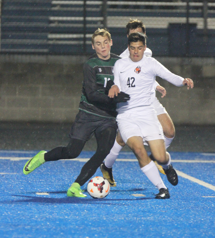   WILLIAM D LEWIS  | THE VINDICATOR..Howlands #42Chris Rubion  and Aurora #12 Cade Huffman battle for the ball behind them is Howland #7 Stevan Gilsic (hidden) Division II regional semifinal boys soccer Howland vw Aurora at Ravenna Stadium..-30-