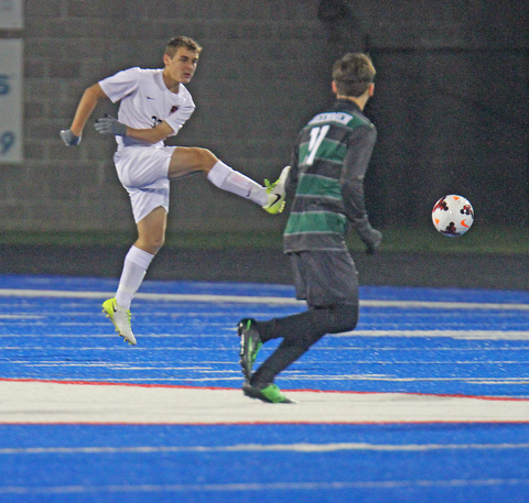   WILLIAM D LEWIS  | THE VINDICATOR..Howland #33  Gabe Altawil  moves the ball away from Aurora Defender #11  Nate Malinowski during Division II regional semifinal boys soccer Howland vw Aurora at Ravenna Stadium..-30-