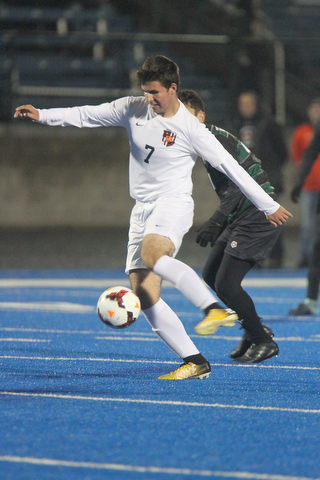   WILLIAM D LEWIS  | THE VINDICATOR..Howlands #7 Steven Glisic moves the ball away from Aurora #41  Rees Jones during first half action Division II regional semifinal boys soccer Howland vw Aurora at Ravenna Stadium..-30-