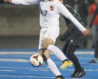 WILLIAM D LEWIS | THE VINDICATOR..Howlands #7 Steven Glisic moves the ball away from Aurora #41 Rees Jones during first half action Division II regional semifinal boys soccer Howland vw Aurora at Ravenna Stadium..-30-