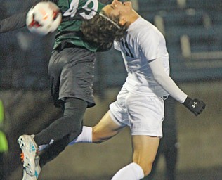 WILLIAM D LEWIS | THE VINDICATOR..Howlands #11 Jonah Weisman hits the ball back as Aurora #49 Alex Bibza battle for the ball ..Division II regional semifinal boys soccer Howland vw Aurora at Ravenna Stadium..-30-