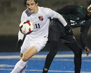 WILLIAM D LEWIS | THE VINDICATOR..Howlands #11 Jonah Wiseman chases after the ball as Aurora #49 Alex Bibza looks on..Division II regional semifinal boys soccer Howland vw Aurora at Ravenna Stadium..-30-