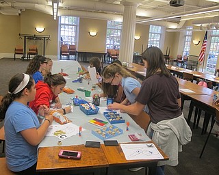 Neighbors | Zack Shively.Children used stamps, glue, glitter and crayons to decorate the ASL sign for the first letter of their name at Poland Library.