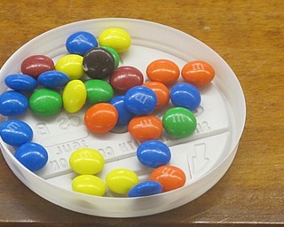 Neighbors | Zack Shively.Librarian Karen Steed placed out M&M's for children to eat at the Poland Library's Snack N Sign event. The candy also helped Steed with an icebreaker that introduced the children to her and the others. For each color, she asked a different question about the person. For example, she asked, “What is something you do well?“ to the students who picked orange.