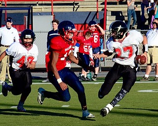 Neighbors | Submitted .Canfield Village Middle School quarterback Broc Lowry (27) tries to avoid a would be Austintown tackler.