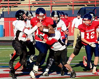 Neighbors | Submitted .Canfield Village Middle School defenders Ryan Schneider (25) and Jeff Demarco (7) work to bring down a Falcon ballcarrier.