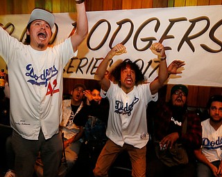 Los Angeles Dodgers fans Mescal Miranda, left, and Max Perez react as they watch the fifth inning of Game 7 of baseball's World Series between the Houston Astros and the Dodgers at The Short Stop bar in Echo Park neighborhood of Los Angeles, Wednesday, Nov. 1, 2017. (AP Photo/Damian Dovarganes)
