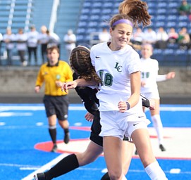 Lake Catholic defender Julia Marusic (18) head butts the ball above Canfield forward Marisa Scheetz (5) during the first half as Lake Catholic High School takes on Canfield High School in the Division II Regional Final, Saturday, Nov. 4, 2017, at Gilcrest Field at Portage Community Bank Stadium in Ravenna, Ohio. Lake won 2-0...(Nikos Frazier | The Vindicator)..