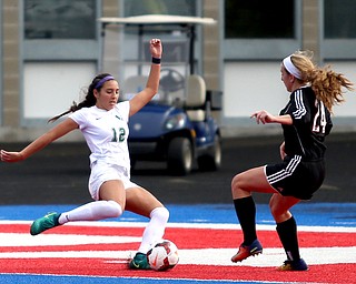 Lake Catholic midfielder Kati Druzina (12) attempts to kick the ball around Canfield defender Ally Stein (24) during the second half as Lake Catholic High School takes on Canfield High School in the Division II Regional Final, Saturday, Nov. 4, 2017, at Gilcrest Field at Portage Community Bank Stadium in Ravenna, Ohio. Lake won 2-0...(Nikos Frazier | The Vindicator)..