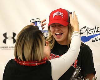Adria Powell cringes as her mom, Olivia Powell, adjusts her Ohio State hat, after Adria signed her letter of intent to attend Ohio State University and play volleyball, Wednesday, Nov. 8, 2017, in the Hubbard High School Gymnasium in Hubbard. ..(Nikos Frazier | The Vindicator)