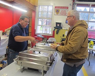 Neighbors | Zack Shively.Firefighter Paul Gugliotti handed out pancakes and sausages for the Poland fire department's breakfast on Oct. 29. Entry for the event was a donation of any amount. The proceeds went toward the department.