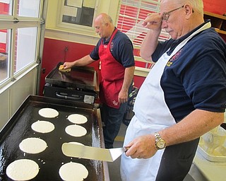 Neighbors | Zack Shively.Firefighters George Brown (front) and Tom Cichon (back) cooked for the fire department's breakfast. The fire department offered bananas and apples to the public. They had coffee, tea and water for beverages.