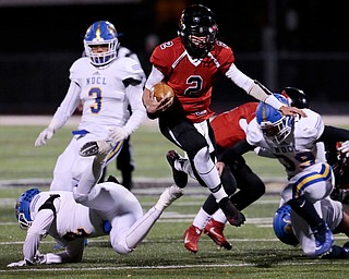 WARREN, OHIO - NOVEMBER 10, 2017:  Canfield's Vinny Fiorenza (2) leaps over NDCL Matt Tuohey (2) as he gains a 1st down  during the 1st qtr. at Harding High School, Mollenkopf Stadium.  MICHAEL G TAYLOR | THE VINDICATOR