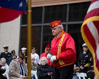 Rebecca Devereaux | The Vindicator ..United States Marine Corps veteran Ed Leviseer carries a rose to place on the Vietnam Memorial during the annual Laying of the Roses ceremony in downtown Youngstown on Sunday. The roses are in commemoration for the 100 soldiers lost while serving in the Vietnam War.