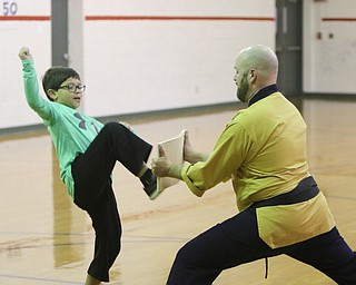   ROBERT K YOSAY  | THE VINDICATOR..Master Justin Taylor Jr., a Taekwondo master  is teaching elementary kids the basics of the martial art this week and how to get along...Mikey Zoccali..  gets ready to break a board.....-30-