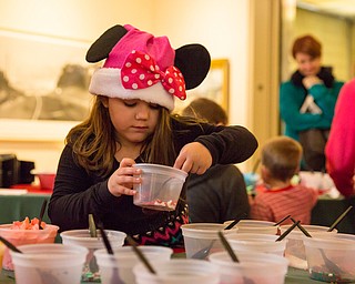 Sarah Marovich, 6 of Boardman scoops some sprinkles for decorating her cookie at the Butler Family Fun Day at the Butler Institute of American Art on Sunday in Youngstown.