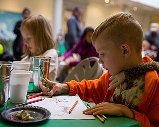 Jamie Jarvis, 8 of Canfield creates his own drawing of Santa Claus at a coloring activity table during the Butler Institute of American Art Museum Family Fun Day on Sunday in Youngstown.