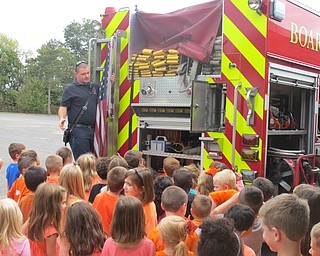 Neighbors | Zack Shively.Jon Park showed different parts of a Boardman fire truck to kindergarten students at Boardman Stadium Elementary School. He opened up all the compartments and equipment on the side and back of the truck to the children.