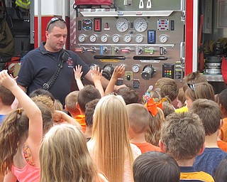 Neighbors | Zack Shively.Boardman firefighter Jon Park fields students' questions about the fire truck gauges and equipment on Oct. 4 in front of Boardman Stadium Elementary.