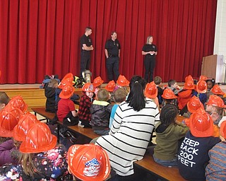Neighbors | Zack Shively.Austintown Elementary School kindergartners listened to a fire safety lesson on dialing 911, smoke detectors, having ways out of a house and fire gear that the fire department uses. The members of the fire department on stage are, from left, firefighter Cameron Long, assistant fire chief Bill Williams and firefighter Sarah Anton.