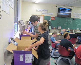 Neighbors | Zack Shively.Scott Lenhart's students Victoria Colovos and and William Parker look through boxes of books to see what new science books the district received from Boardman Subaru.