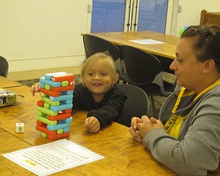 Neighbors | Zack Shively.One game at the Austintown library's "Playtime at Your Library" asked the children to roll die with three different colors on it. The child had to pull a color block and stack it on top. It worked colors and building structures.