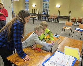 Neighbors | Zack Shively.The children at the Lego WeDo event programmed the machines to move and pull objects. Pictured, librarian Annette Ahrens helped Jack and Logan with making their machine move.