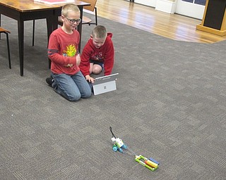 Neighbors | Zack Shively.Children placed blocks on the back of their machine to see how many it could pull. Pictured, Landon and Rowan celebrate their successful robot.